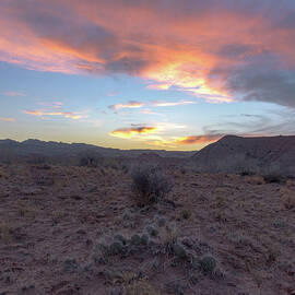 Desert Sunset Over Rugged Terrain by Brandon Wichmann
