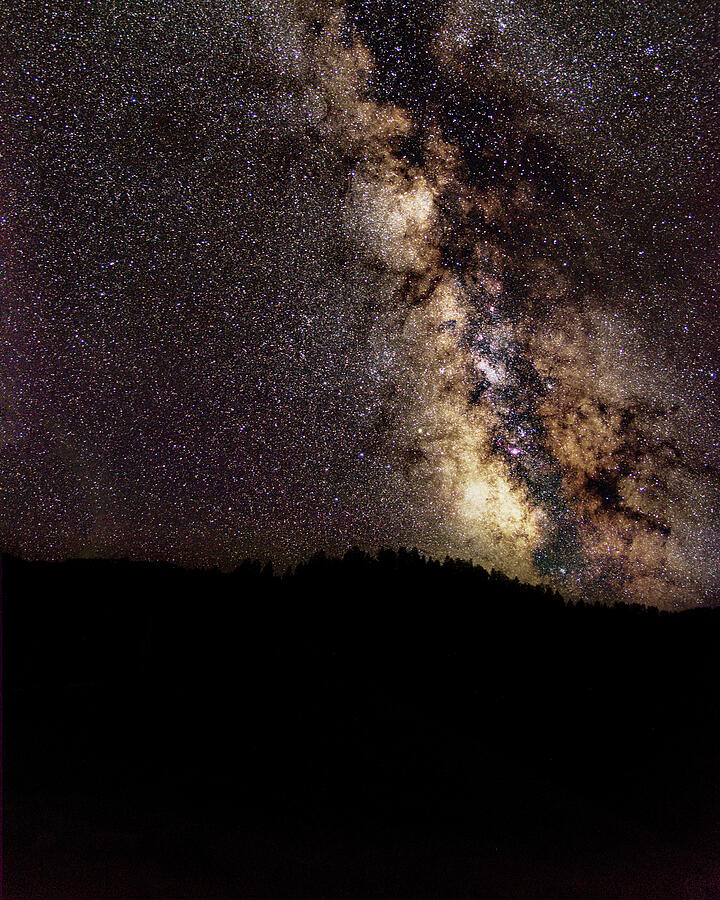 Night Sky Brimming with Stars: the Milky Way above a dark mountain silhouette