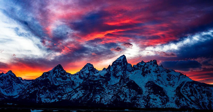 Crimson clouds above a snowy mountain range